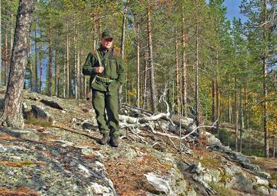Metsästäjä aurinkoisessa rinteessä.